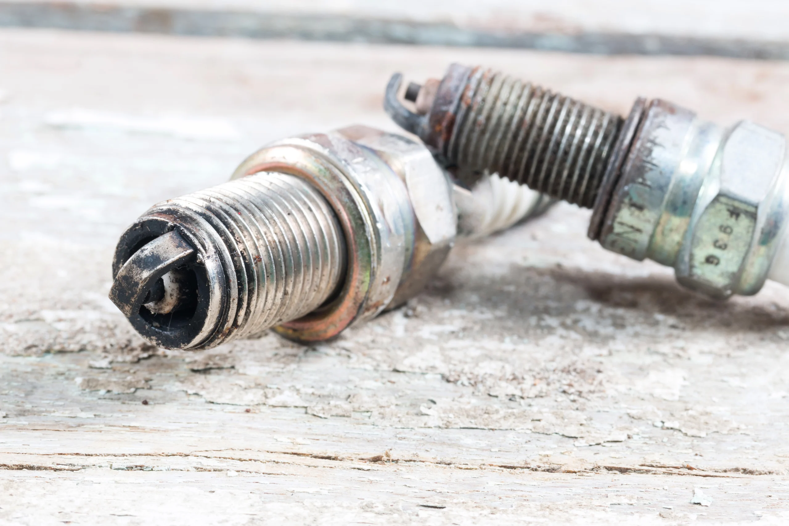Close-up comparison of new vs worn spark plug electrodes
