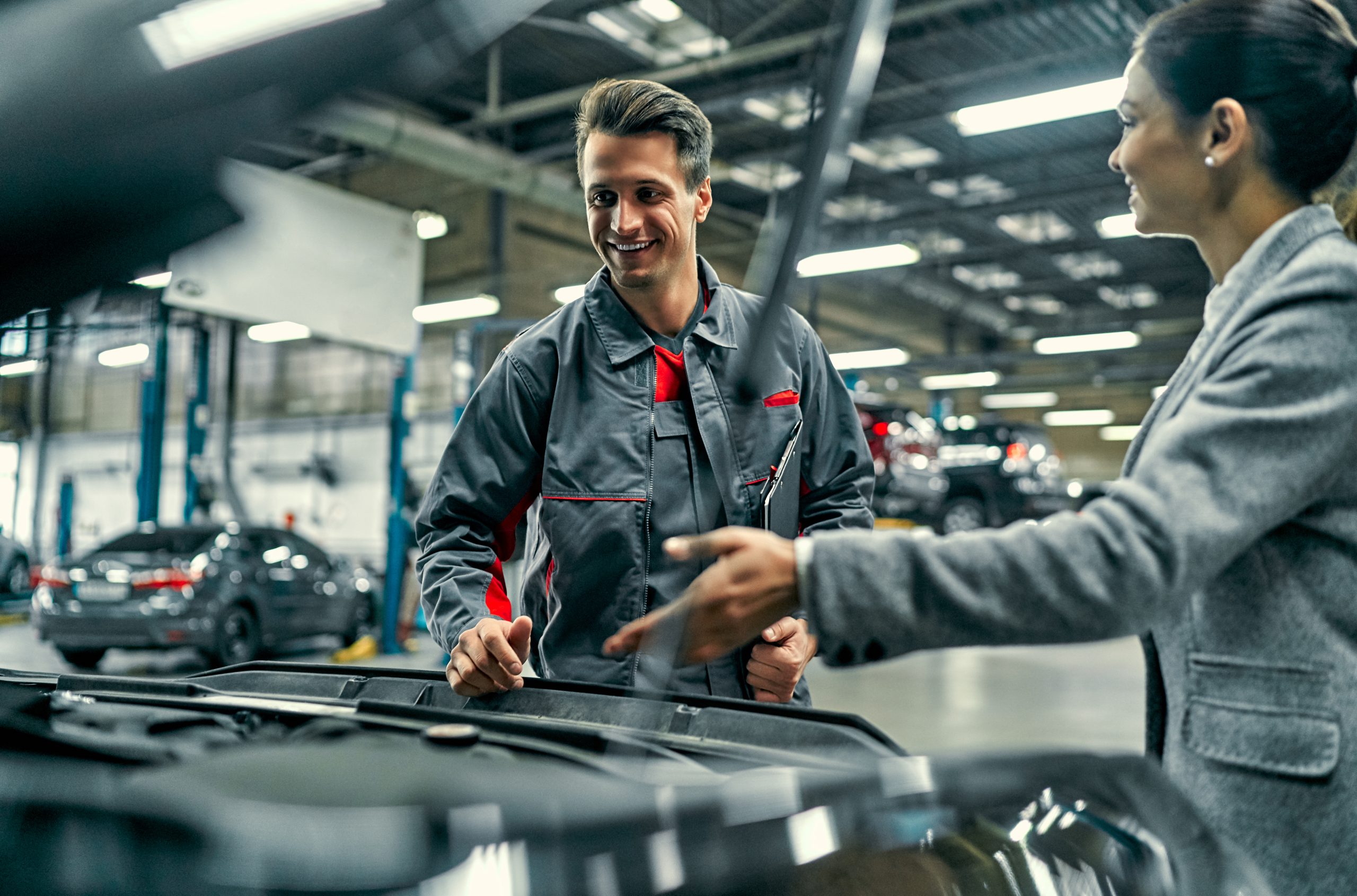 Beautiful,Businesswoman,And,Auto,Service,Mechanic,Are,Discussing,The,Work. Removing,A,Sensor,Located,Under,The,Intake,Manifold.