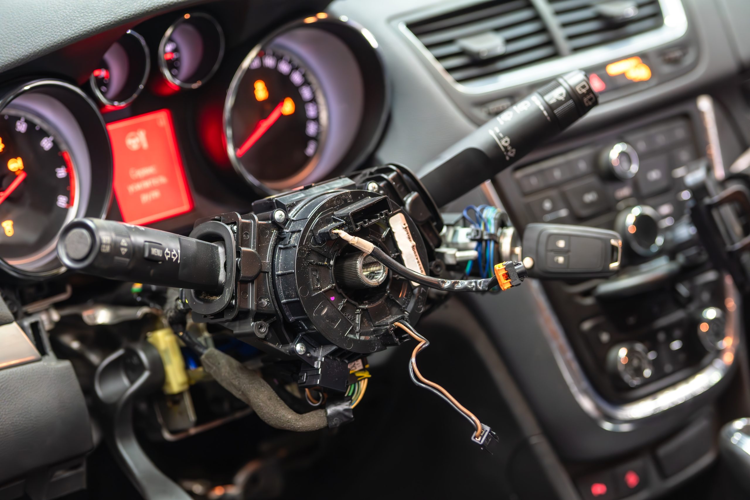 Disassembled,Steering,Column,With,Exposed,Wiring,Inside,A,Modern,Car Close-up of a coil-on-plug ignition coil being removed from an engine