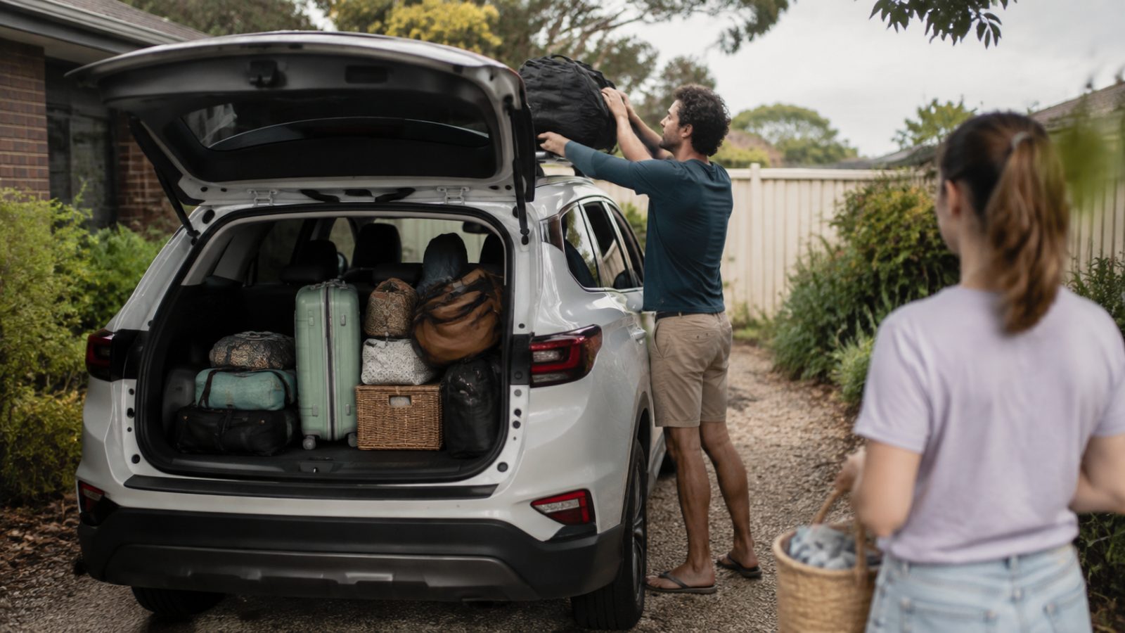 Family car loaded for a road trip in a suburban driveway